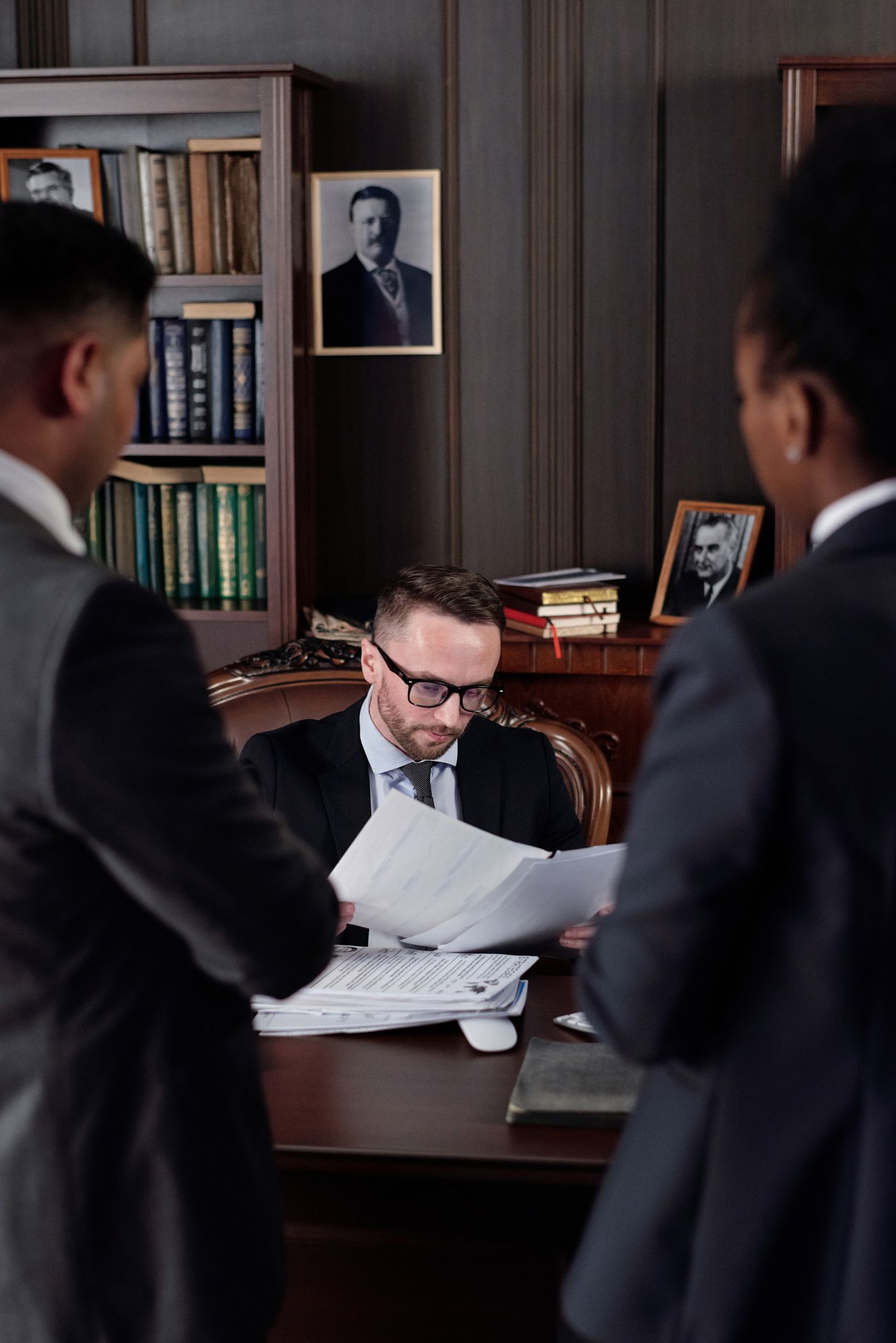 Professionals reviewing formal paperwork across an office table